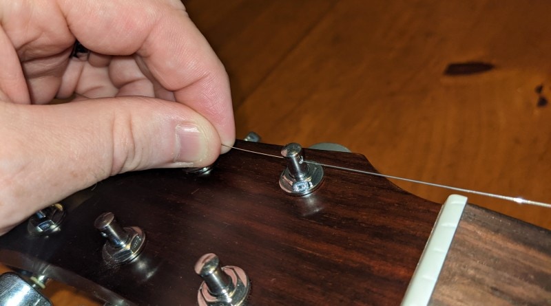 How to Restring an Acoustic Guitar - place loose end into tuning post